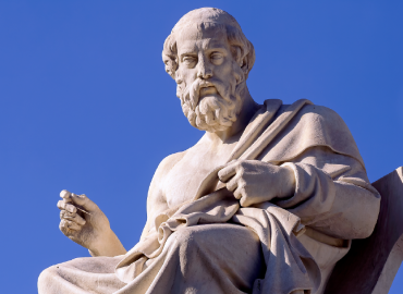 Statue of Plato against a blue sky.